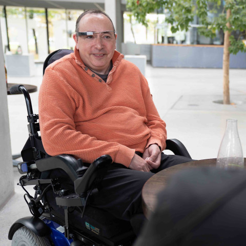 Mann im elektrischen Rollstuhl mit Smart Glasses