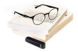 Die Vorlesekamera und eine Brille liegen auf einem Buch